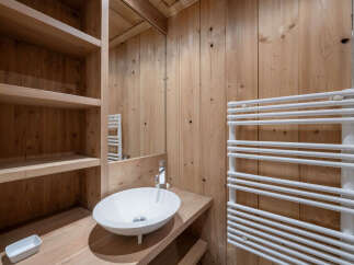 Experience rustic charm in this bathroom featuring a sleek white vessel sink atop a wooden vanity.