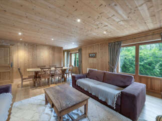 Experience rustic charm in this beautifully appointed living and dining area, featuring warm wooden paneling throughout.
