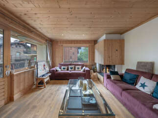 Experience cozy living in this charming mountain retreat, featuring a warm wood-paneled interior and a stunning fireplace.