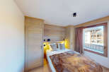 Experience cozy mountain living in this charming bedroom featuring a plush fur throw on the bed and warm wood paneling throughout.
