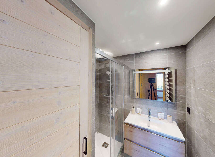 Experience modern comfort in this beautifully appointed bathroom, featuring a sleek shower enclosure and a stylish vanity with ample storage.