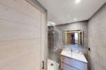 Experience modern comfort in this beautifully appointed bathroom, featuring a sleek shower enclosure and a stylish vanity with ample storage.