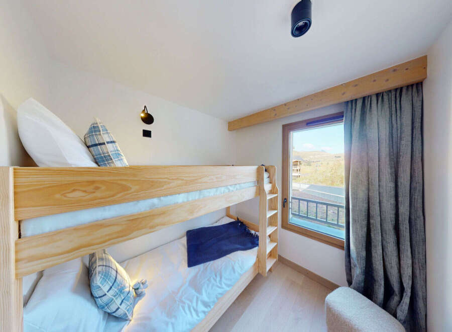 This charming bedroom features a sturdy wooden bunk bed, perfect for families or accommodating guests.