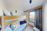 This charming bedroom features a sturdy wooden bunk bed, perfect for families or accommodating guests.