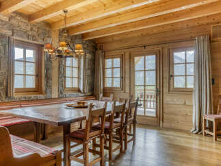Experience rustic charm in this mountain chalet dining room, featuring a large wooden table and benches perfect for gathering.