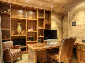 Discover this charming office space featuring rich wooden paneling and built-in shelving, perfect for a home study or professional workspace.