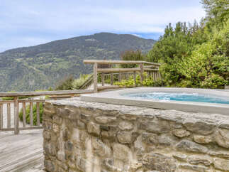 Experience ultimate relaxation with this stunning outdoor hot tub, perfectly integrated into a natural stone base.