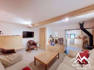 Discover this charming living room featuring a cozy seating area with plush sofas and a leather armchair, perfect for relaxation.