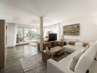 Experience modern living in this spacious living room, featuring a large white sectional sofa and a sleek entertainment center.