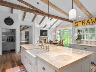 Experience rustic charm and modern luxury in this stunning kitchen, featuring exposed wooden beams and a vaulted ceiling.