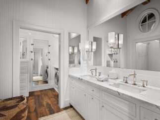 This luxurious bathroom features a spacious double vanity with marble countertops and elegant brass fixtures.