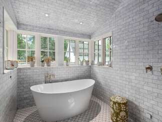 Indulge in luxury in this stunning bathroom, featuring a freestanding soaking tub and elegant marble tilework throughout.