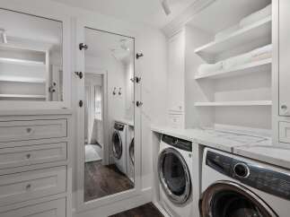 This laundry room boasts a sleek and modern design with a stacked Electrolux washer and dryer set.