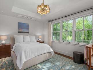 Experience serene living in this beautifully appointed bedroom, featuring a plush king-sized bed dressed in crisp white linens.