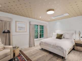 This charming bedroom features a unique star-patterned ceiling that adds a whimsical touch to the space.