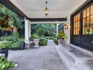 Step into luxury with this stunning entryway featuring a covered porch and elegant double doors.