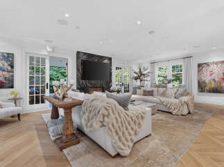 Experience luxurious living in this stunning living room, featuring a modern marble fireplace with a large flat-screen TV.