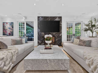 Experience luxury living in this stunning living room, featuring a sleek marble coffee table and a dramatic black marble fireplace.