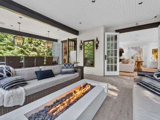 Experience luxurious outdoor living with this stunning covered patio, featuring a modern gas fire pit perfect for cozy evenings.