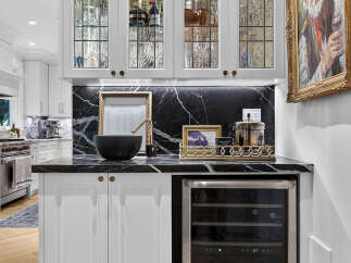 Elevate your entertaining with this stylish bar area, featuring elegant glass-fronted cabinetry filled with a curated selection of spirits and glassware.