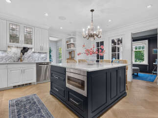 Experience luxury in this stunning kitchen featuring a spacious island with a built-in microwave and ample storage.