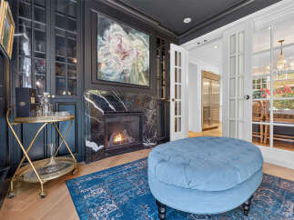 Experience luxury living with this stunning room featuring a modern fireplace and elegant built-in cabinetry.