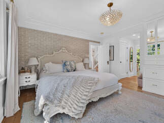 Experience luxury in this master bedroom featuring a stunning upholstered headboard and a plush, textured throw blanket.