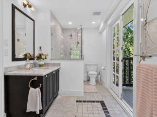 This elegant bathroom features a spacious walk-in shower with marble tile and a modern glass enclosure.
