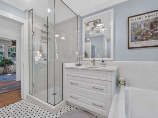 Experience luxury in this beautifully renovated bathroom, featuring a sleek glass-enclosed shower and a modern vanity with ample storage.