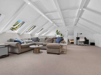 This spacious attic living area boasts a large sectional sofa perfect for relaxation and entertainment.