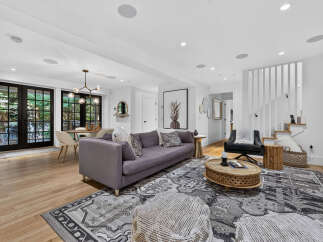 Step into this beautifully designed living space, featuring a plush purple sofa and a striking pineapple artwork that adds a unique touch.