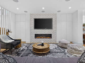 Experience modern living in this stylish living room featuring a sleek electric fireplace set against a white brick accent wall.