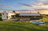 Experience luxury living in this stunning modern farmhouse, featuring a sleek white exterior and a durable metal roof.