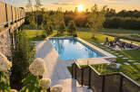 Experience luxury outdoor living with this stunning backyard oasis, featuring a pristine rectangular swimming pool surrounded by elegant stone pavers.