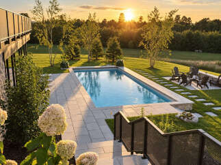 Experience luxury outdoor living with this stunning backyard oasis, featuring a pristine rectangular swimming pool surrounded by elegant stone pavers.