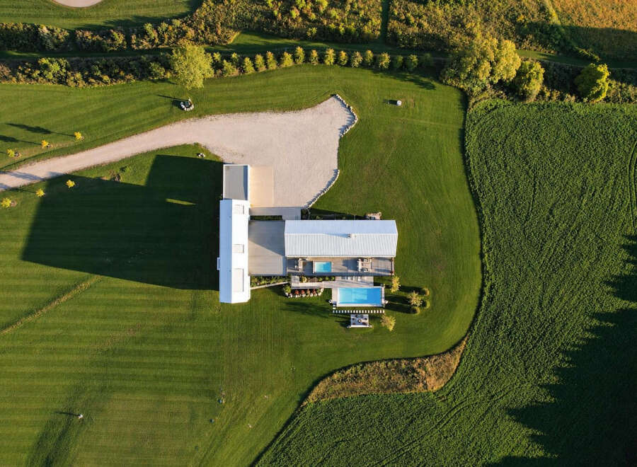 Experience modern luxury with this stunning aerial view of a contemporary home featuring a sleek design and expansive grounds.