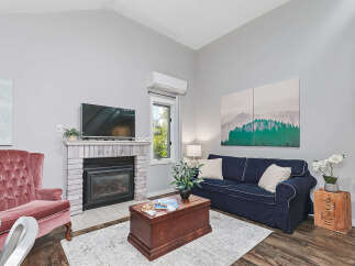 Cozy living room featuring a plush pink armchair and a comfortable navy blue sofa, perfect for relaxing evenings.