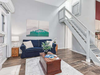 Discover this charming living space featuring a cozy navy blue sofa adorned with decorative pillows, perfect for relaxation.