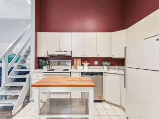Discover this charming kitchen featuring a butcher block island, perfect for meal prep and casual dining.