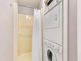 This bathroom features a convenient stacked washer and dryer unit, perfect for maximizing space.