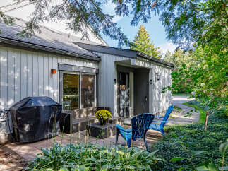 Enjoy outdoor living with this charming patio featuring a covered grill and comfortable seating.