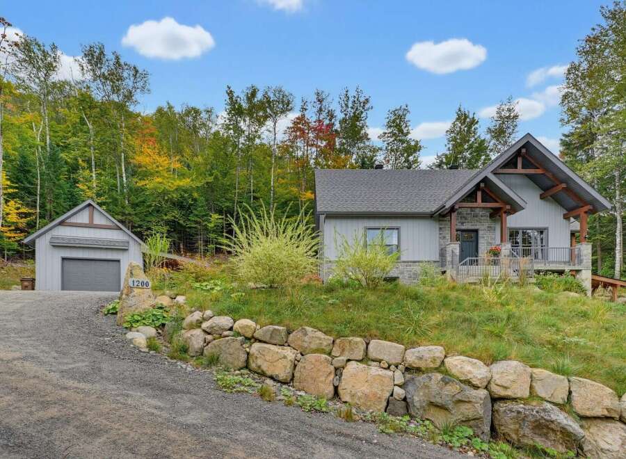 Discover this stunning mountain retreat featuring a modern A-frame home with stone accents and a detached garage.
