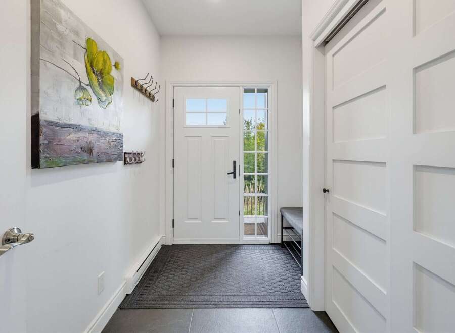 Step into this welcoming entryway featuring a bright front door with a glass pane, perfect for natural light.