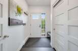 Step into this welcoming entryway featuring a bright front door with a glass pane, perfect for natural light.