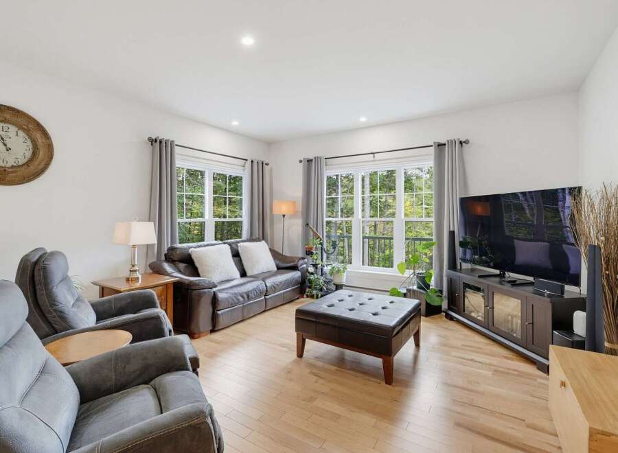Experience comfortable living in this inviting living room, featuring plush leather seating and a large ottoman perfect for relaxation.