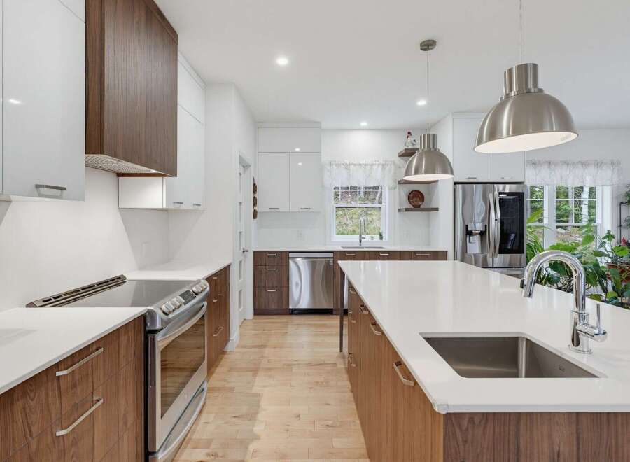 Experience modern luxury in this stunning kitchen, featuring sleek white cabinetry contrasted with rich walnut wood accents.