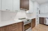 Experience modern living in this stunning kitchen, featuring sleek white cabinetry contrasted with rich wood accents.