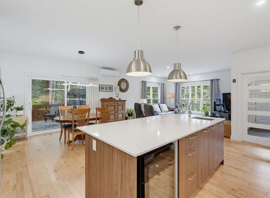 This spacious open-concept kitchen and living area boasts a large island with a built-in wine fridge, perfect for entertaining.