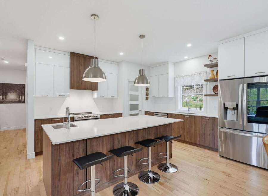 Experience modern luxury in this stunning kitchen, featuring sleek white cabinetry contrasted with rich wood accents.