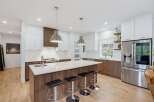 Experience modern luxury in this stunning kitchen, featuring sleek white cabinetry contrasted with rich wood accents.